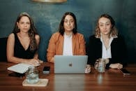 Women Sitting at Table with Laptop Looking