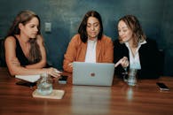 Women at a Meating, Using Laptop at a Wooden Table