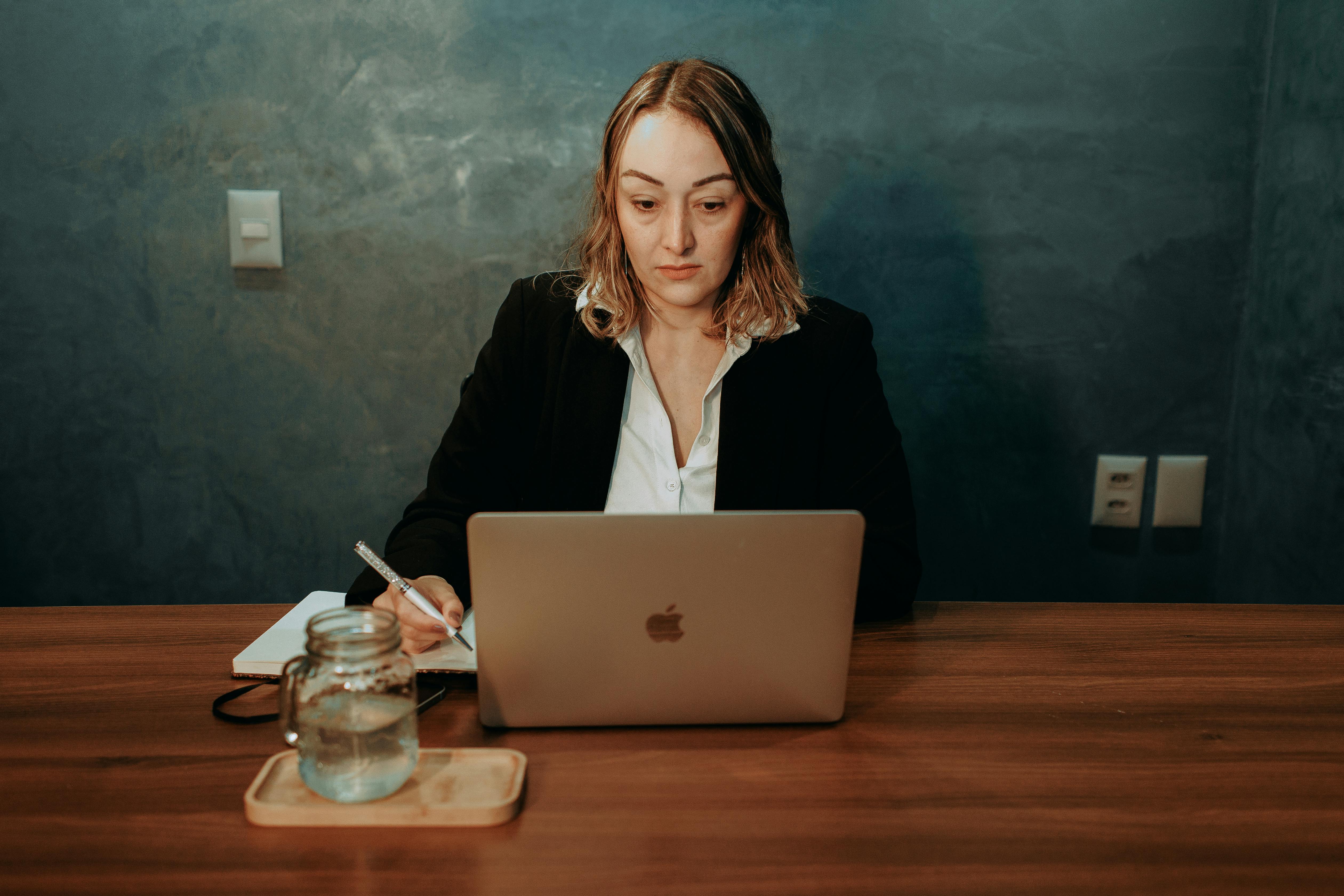 woman in suit jacket sitting and working