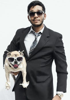 Man and pug in matching suits and sunglasses striking a humorous and stylish pose.