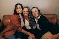 Women Sitting Together on Sofa and Smiling