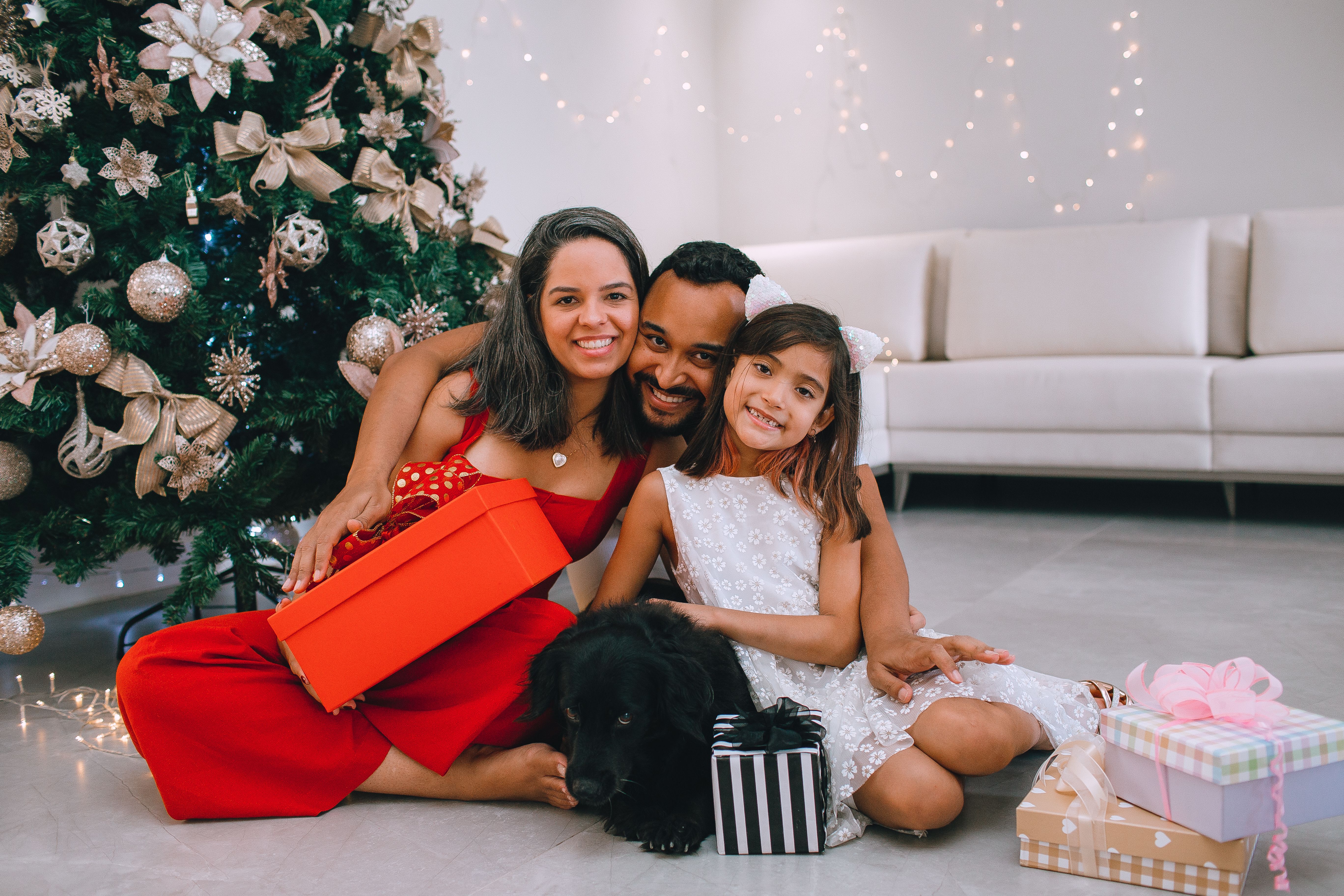 A joyful family celebrating Christmas with gifts and a decorated tree.