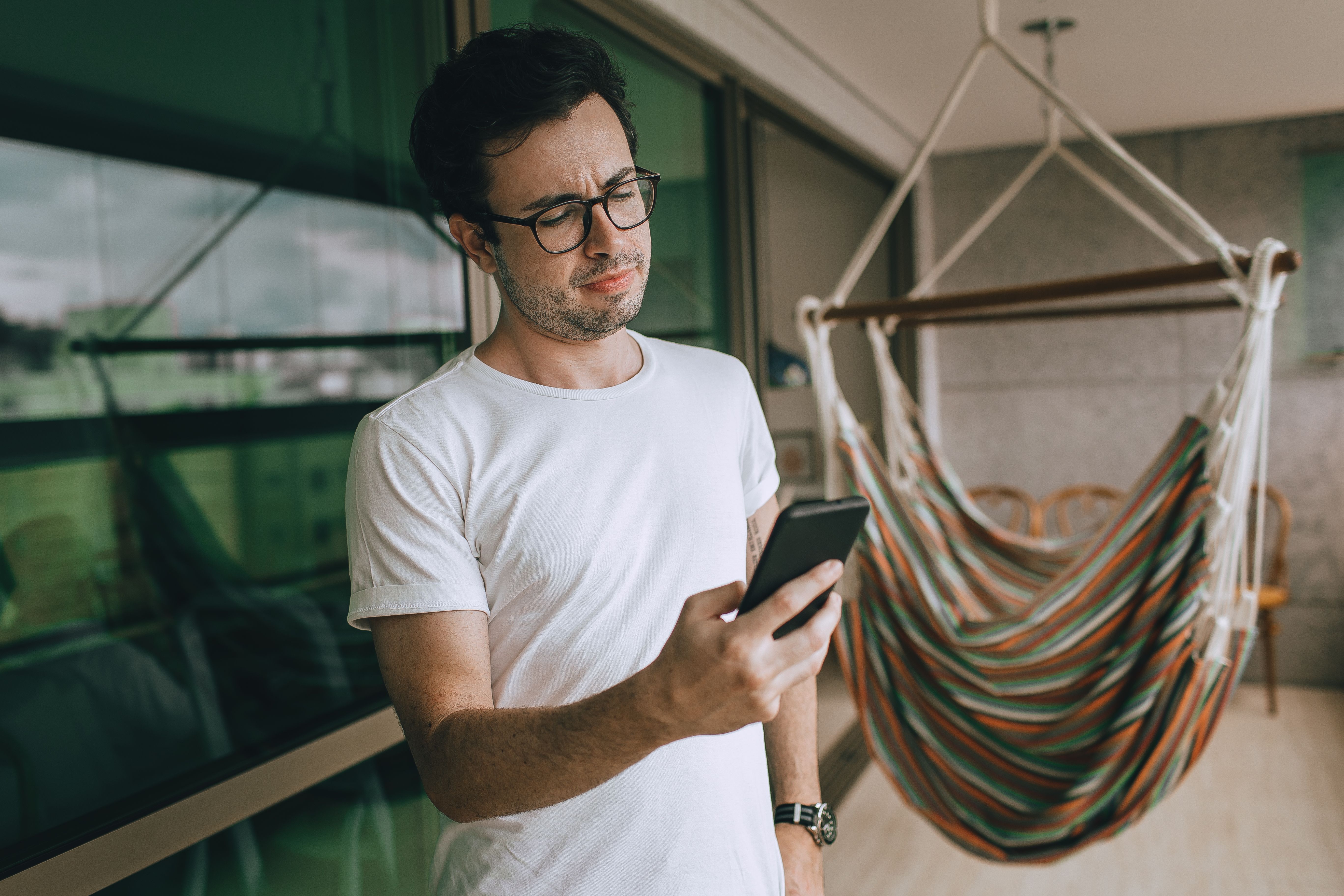 person reading news headlines on smartphone with coffee, thoughtful expression