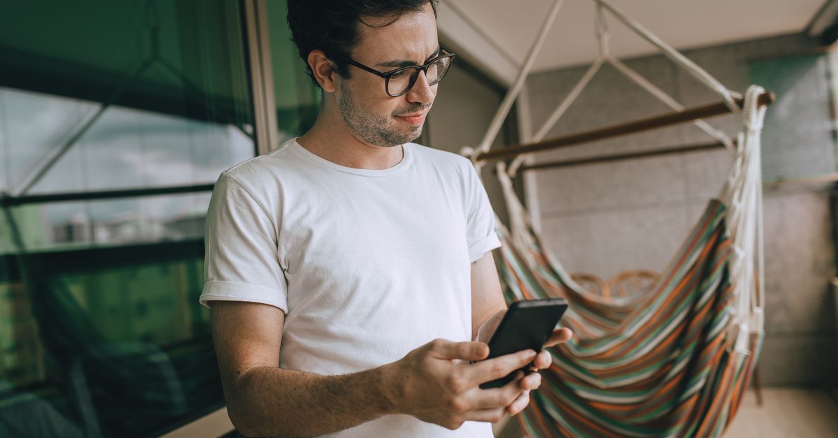 person scrolling news headlines on smartphone looking skeptical
