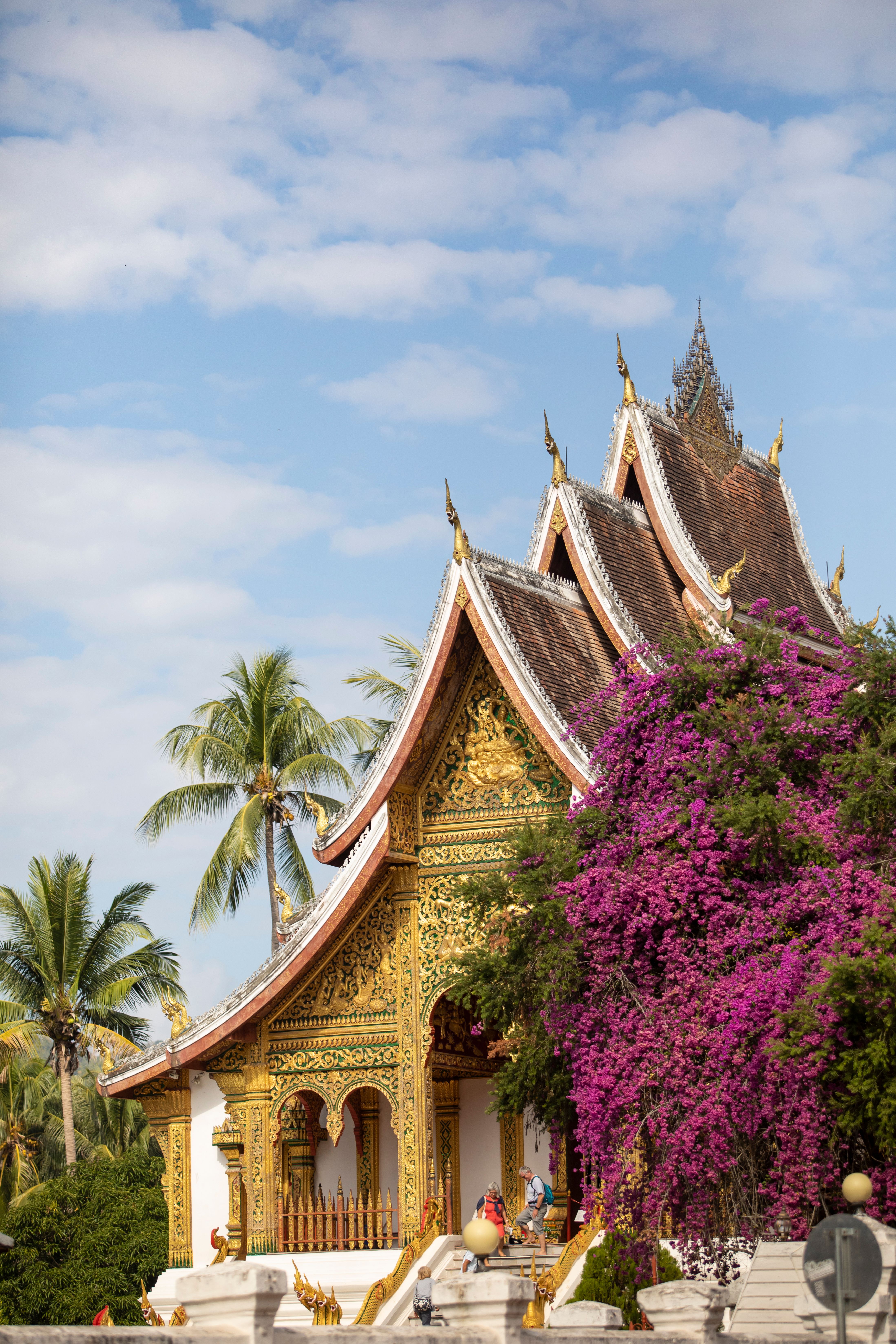 Ornate multi-tiered roof of Wat Xieng Thong temple with intricate gold mosaic detail in Luang Prabang
