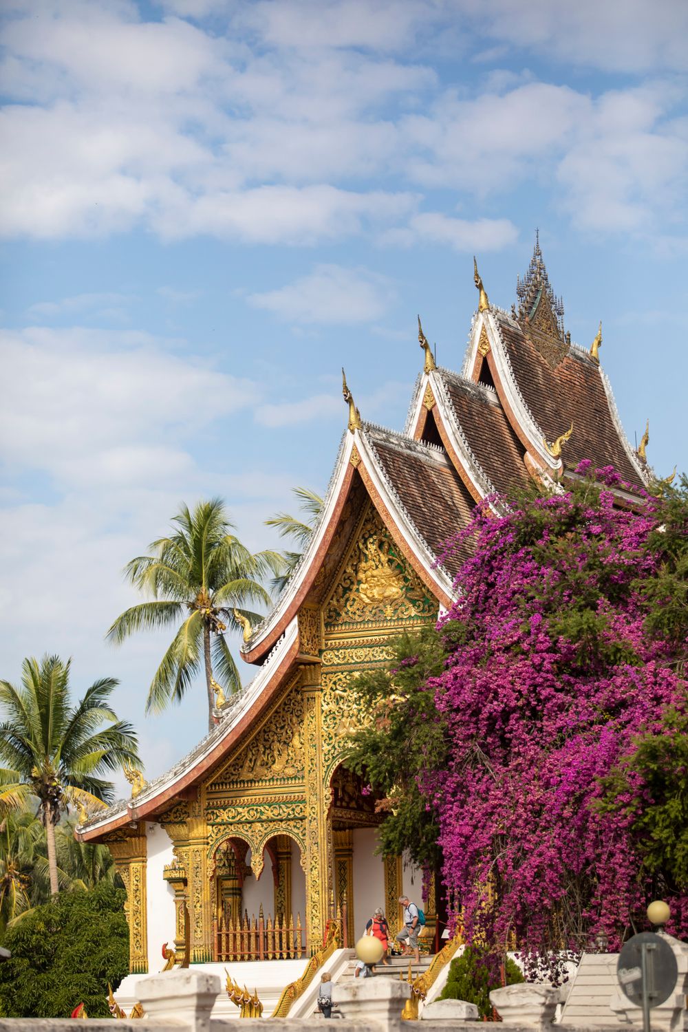Ornate multi-tiered roof of Wat Xieng Thong temple with intricate gold mosaic detail in Luang Prabang