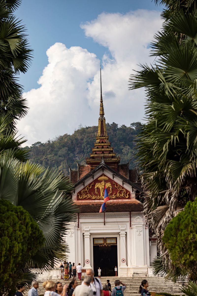 Royal Palace Museum in Luang Prabang with its golden spire framed by palm trees