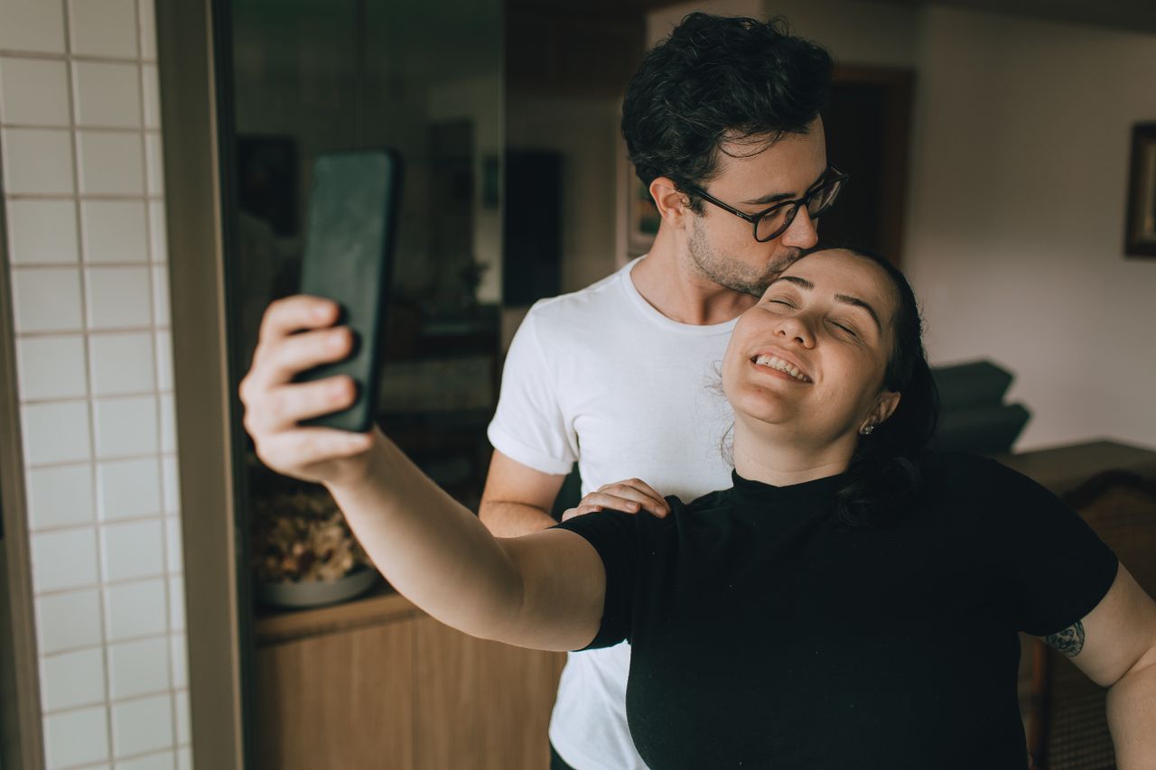 A joyful couple capturing a selfie moment indoors