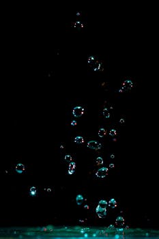 Captivating photo of water bubbles suspended in motion against a dark background.