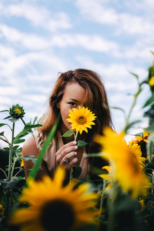 Woman Standing Beside Sunflowers