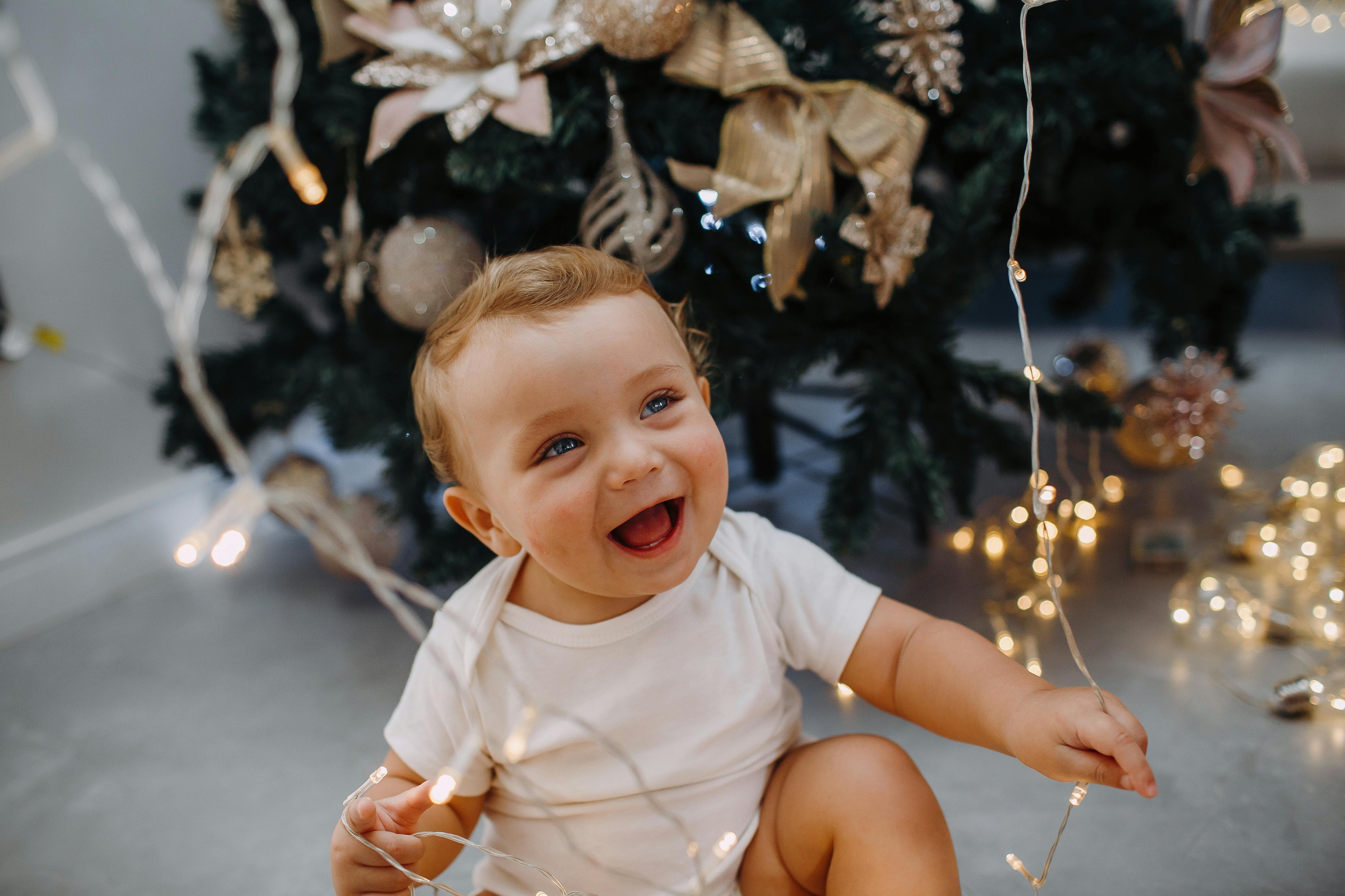 laughing boy sitting and holding christmas lights