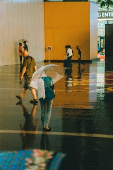 People walking with umbrellas on a rainy day in Kuala Lumpur, Malaysia.