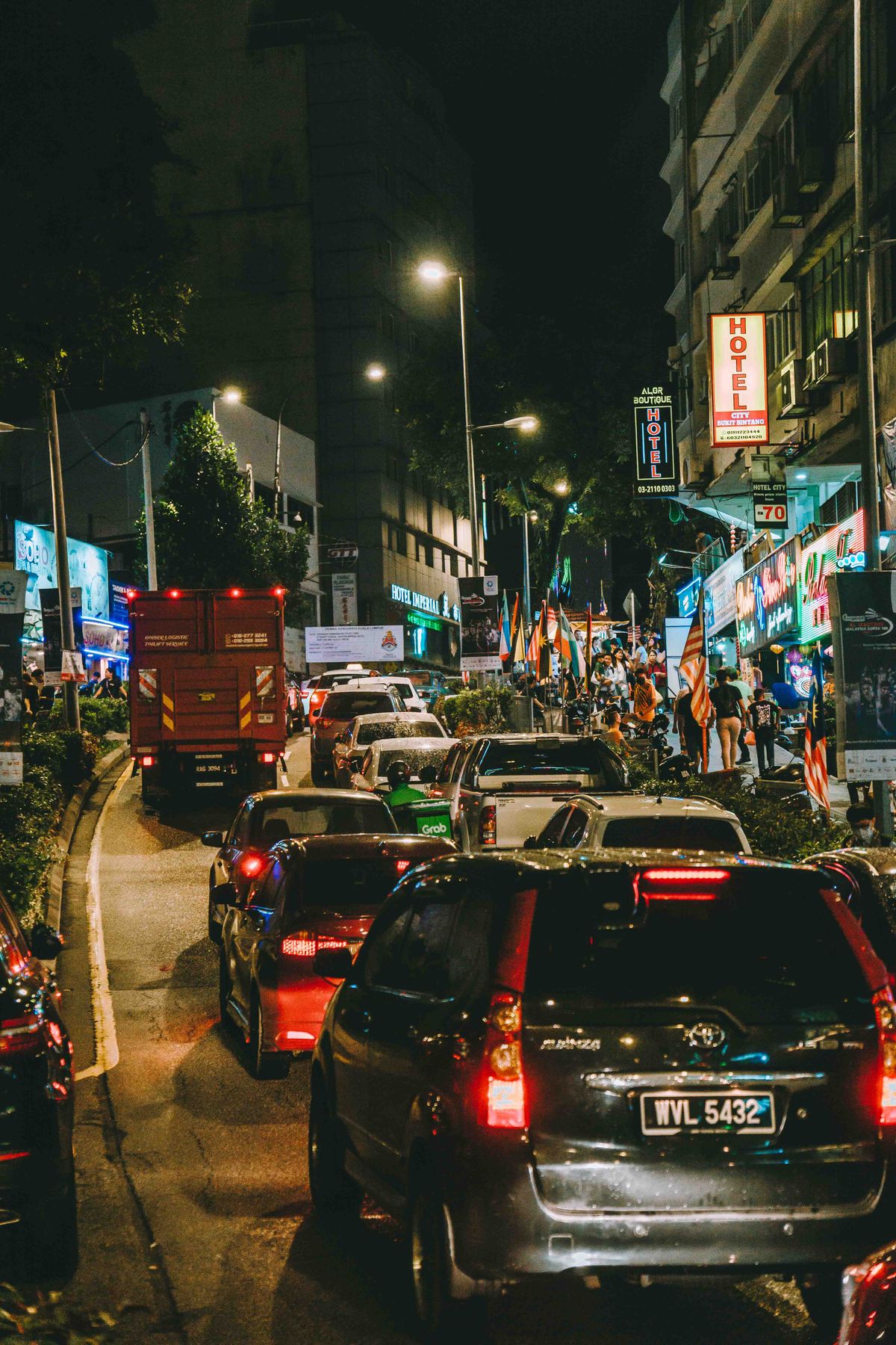 Logistics lorry in night traffic in Kuala Lumpur, Malaysia — the low-light conditions where window stickers matter most