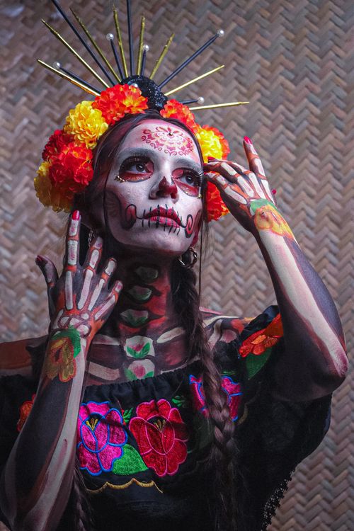 Free Vibrant portrait of a woman in traditional Mexican Day of the Dead makeup with flowers. Stock Photo