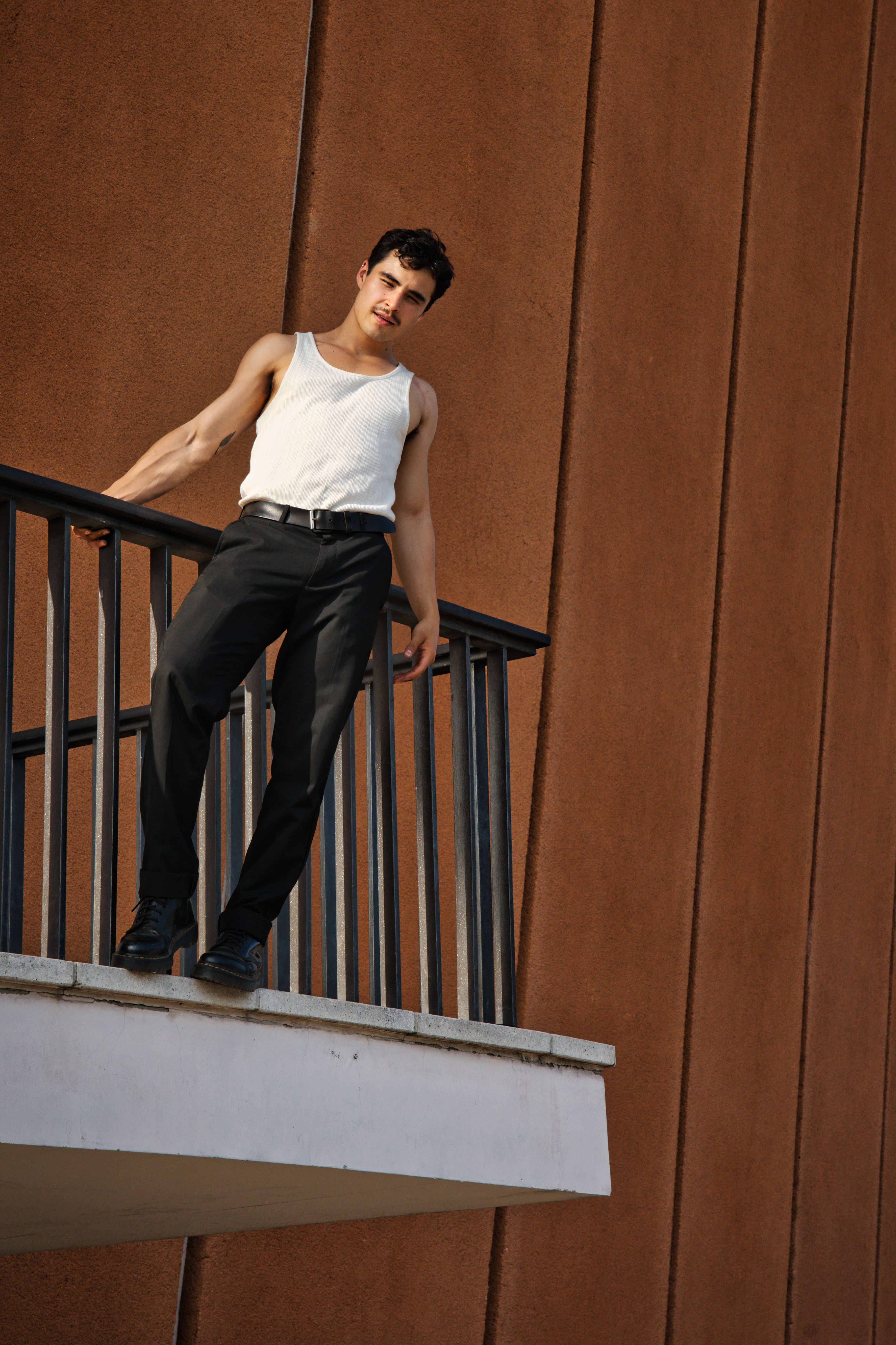 Man in Tank Top Standing behind Railing · Free Stock Photo