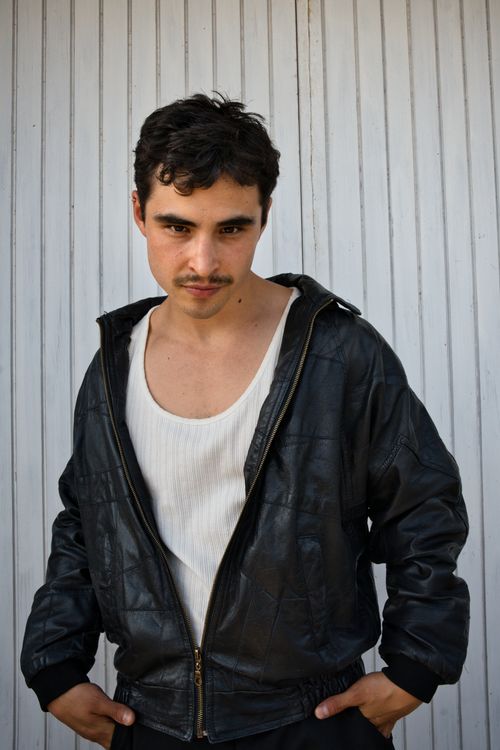 Free Portrait of a young man with mustache and brown hair wearing a leather jacket in Berlin. Stock Photo