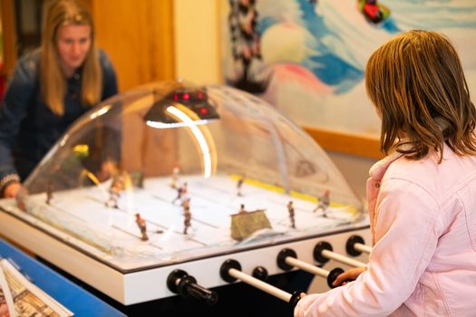 Two teenagers playing table hockey indoors, Yellowknife, NT, Canada.