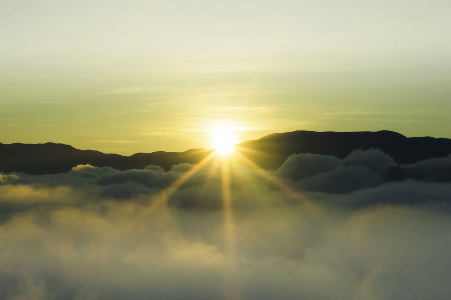 Sunbeams through mountain fog