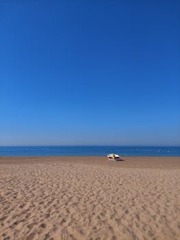 Serene empty beach scene with a small boat on the shoreline, perfect for relaxation and tranquility.