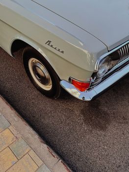 Close-up of a classic vintage car parked on a city street, showcasing retro design.