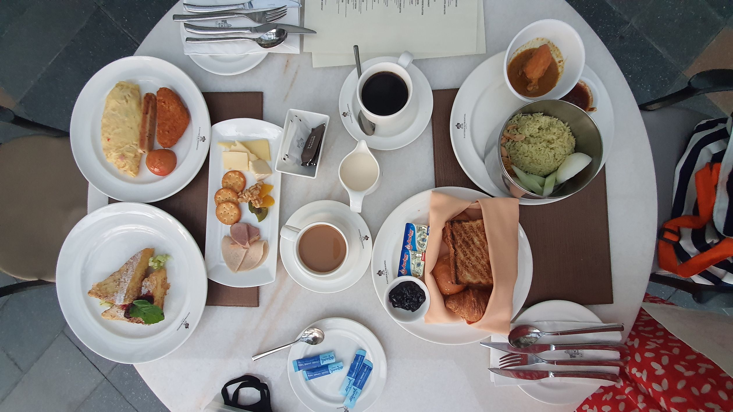 A diverse breakfast spread with coffee, toast, pastries, and more, elegantly arranged on a dining table.