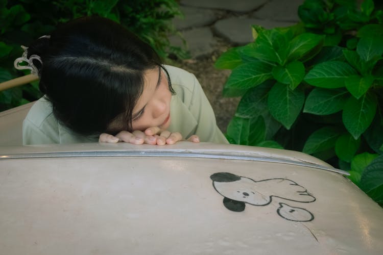 Girl Leaning Against A Puppy Drawing On Metal