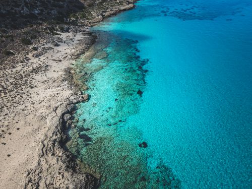 Free Breathtaking aerial shot of an untouched turquoise coastline, perfect for travel and nature themes. Stock Photo