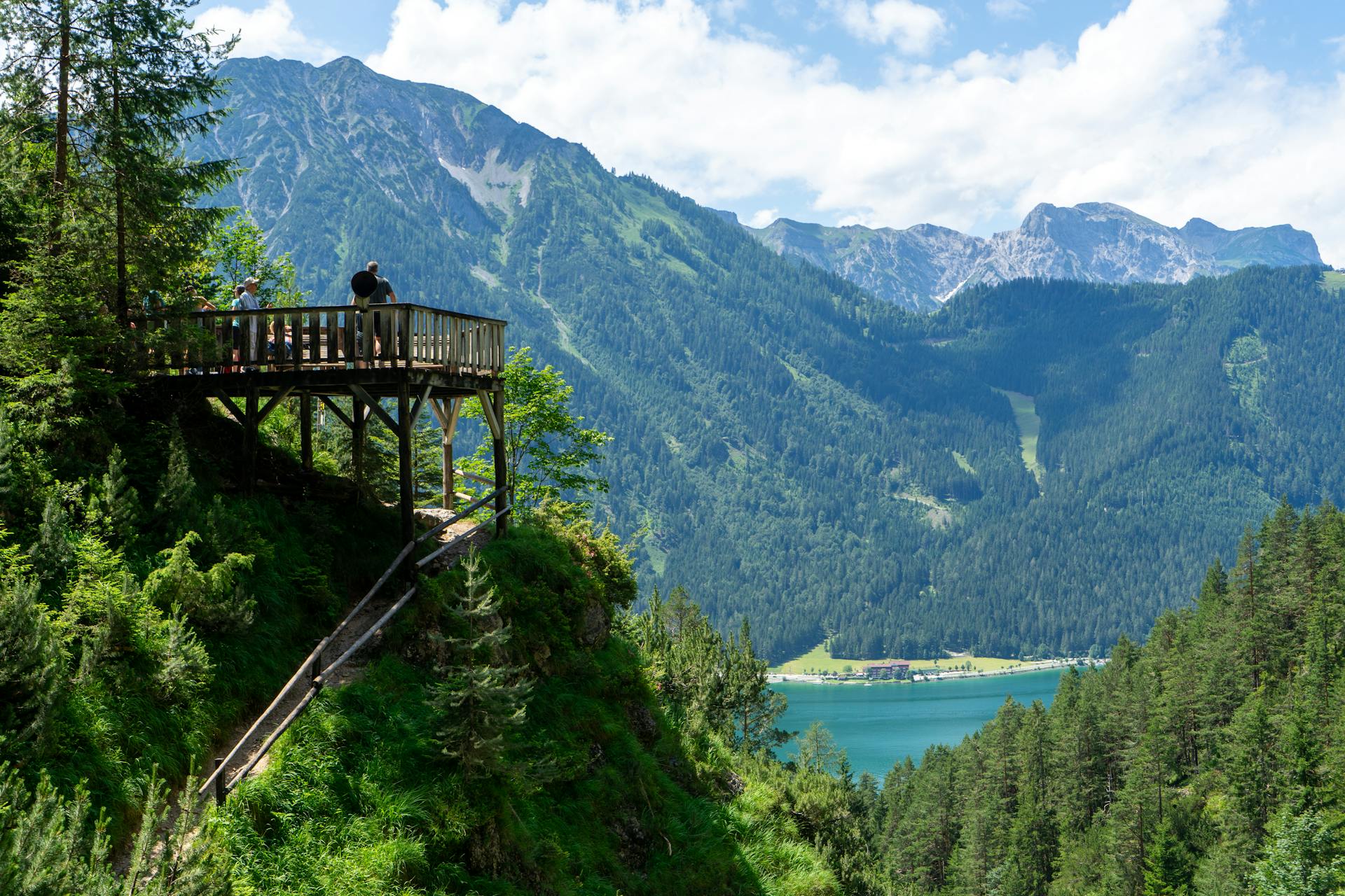 Breathtaking view of Tirol mountains and lake from a wooden viewpoint in Maurach, Austria.