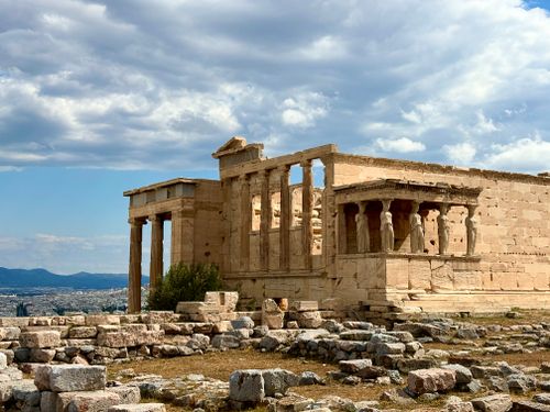 Free Historic Erechtheion temple on Athens Acropolis, Greece, under a dramatic cloudy sky. Stock Photo