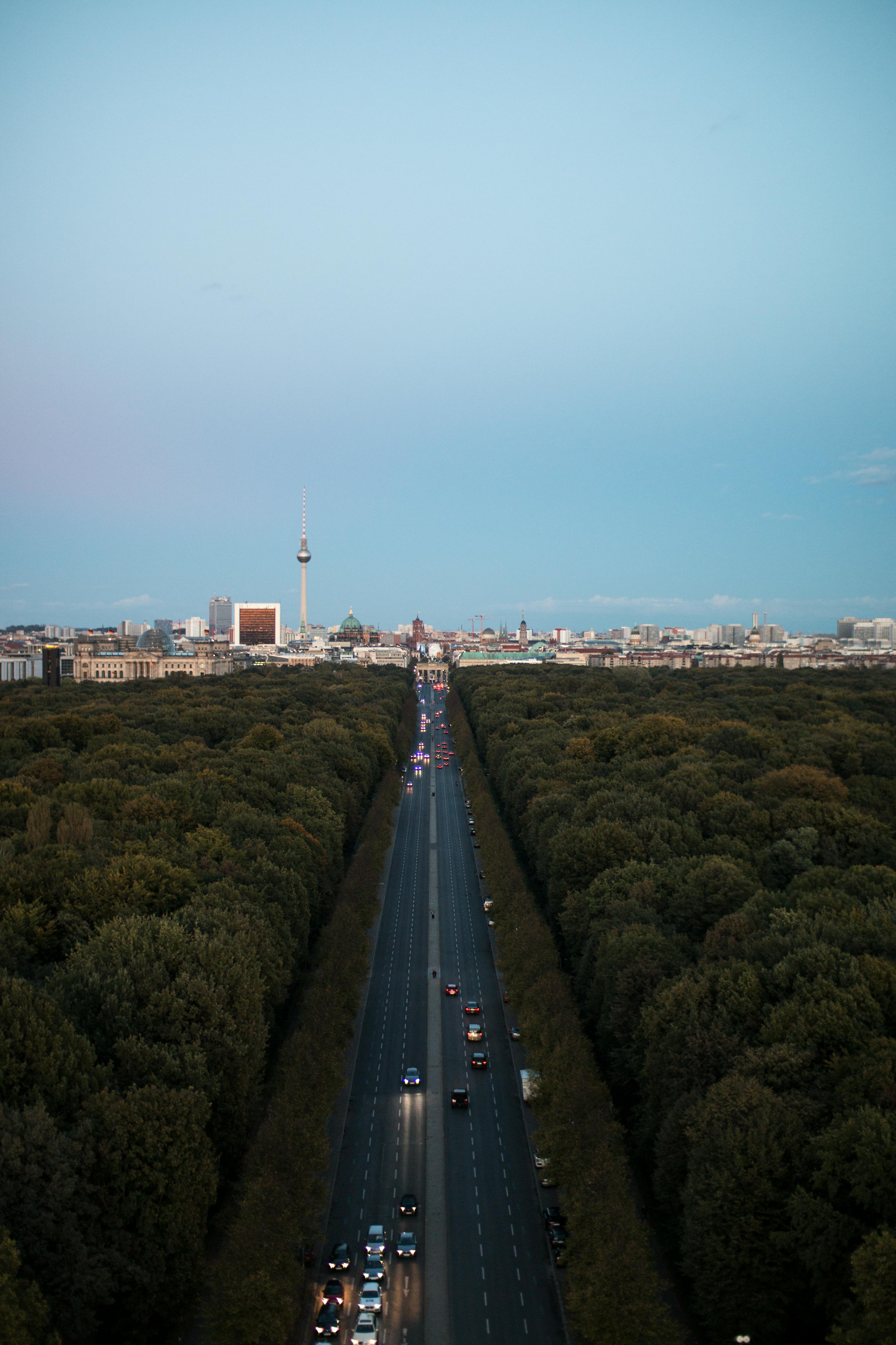 Stunning aerial view of Berlin's iconic TV Tower with a sunset backdrop and busy road.