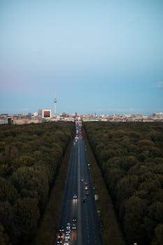 Stunning aerial view of Berlin's iconic TV Tower with a sunset backdrop and busy road.