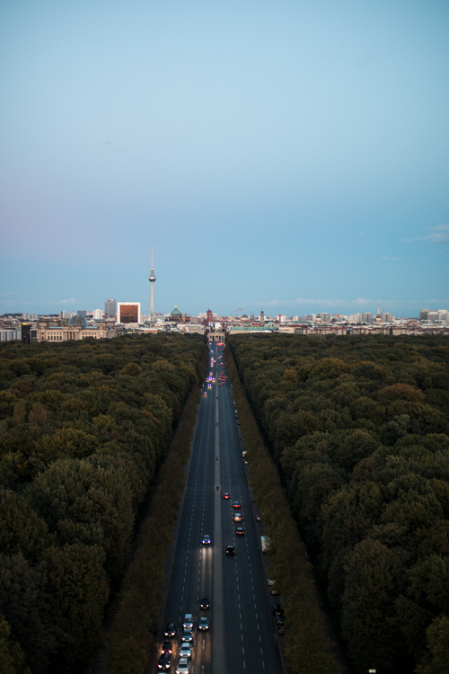 Free Stunning aerial view of Berlin's iconic TV Tower with a sunset backdrop and busy road. Stock Photo