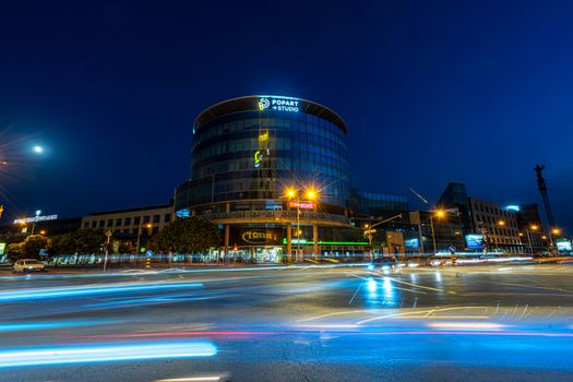 Illuminated cityscape of Novi Sad, Serbia, with motion blur capturing evening traffic movement.