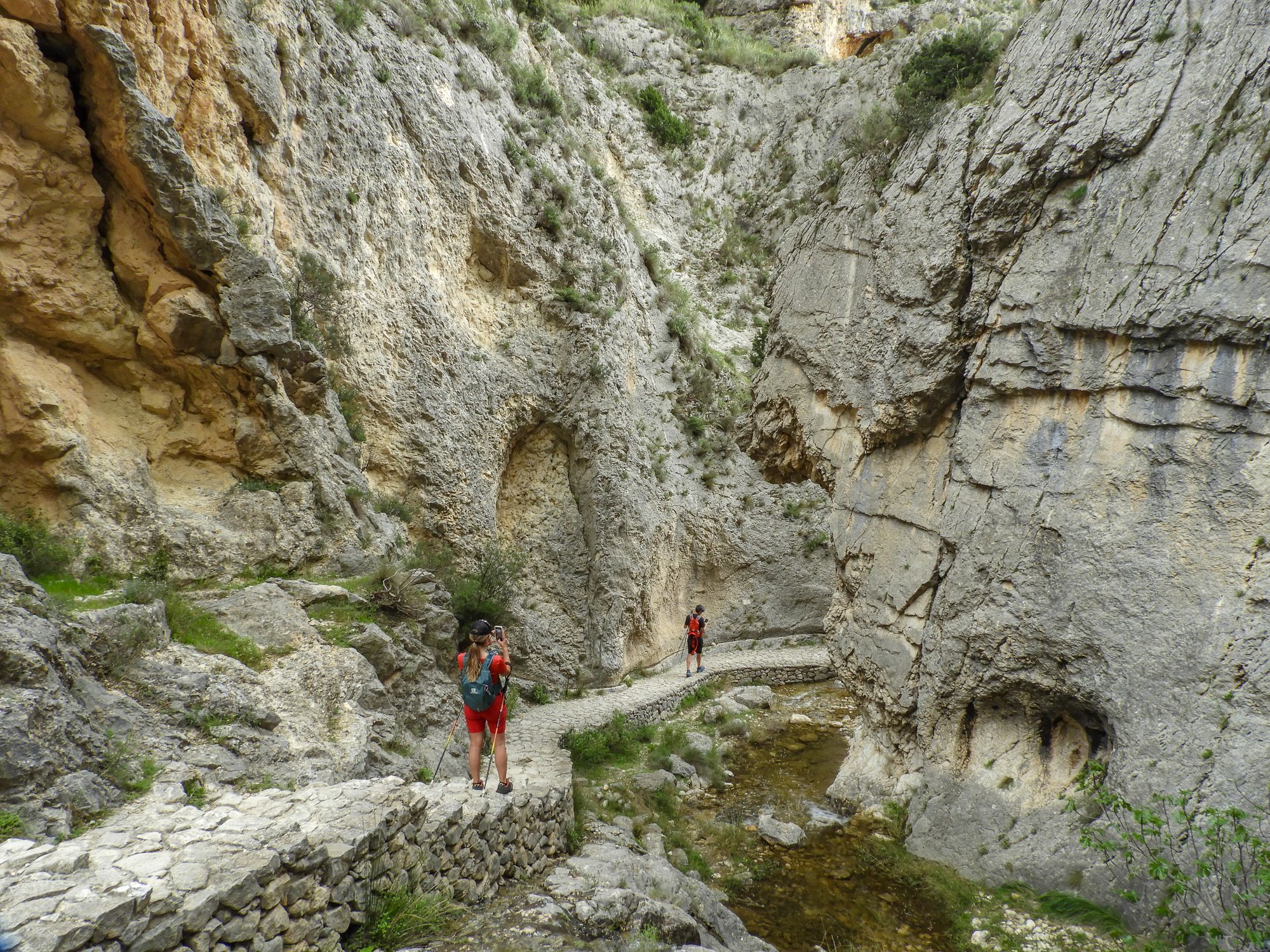 Sendero estrecho tallado en la pared de un desfiladero de piedra caliza sobre un río