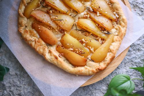 Free Delicious homemade pear tart with fresh ingredients on a rustic table. Stock Photo