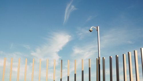 Free A surveillance camera mounted on a pole under a clear blue sky, capturing urban security essence. Stock Photo