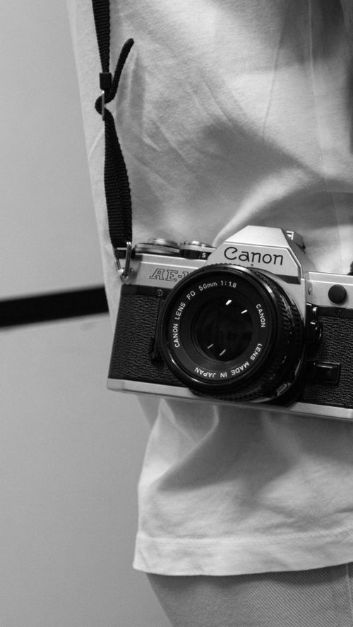 Free A classic Canon film camera captured in a stylish black and white close-up. Stock Photo