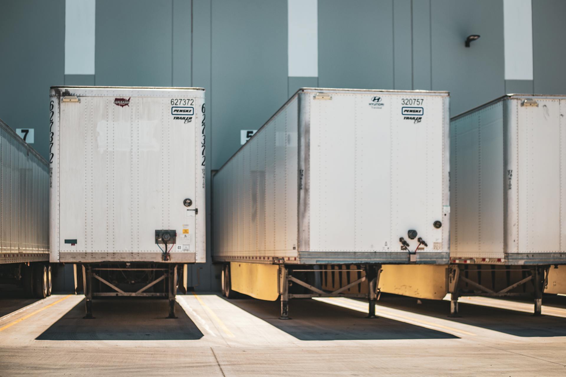 En rad lasttrailers parkerade vid en kommersiell lastdok, med tonvikt på transport och logistik.