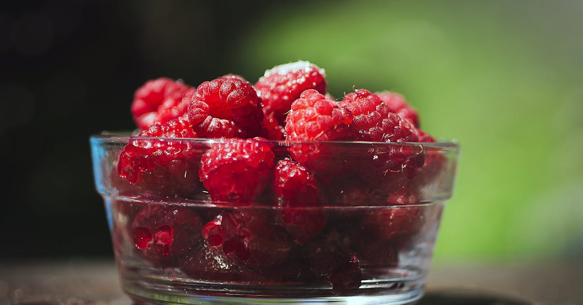 A bowl of raspberries on a table