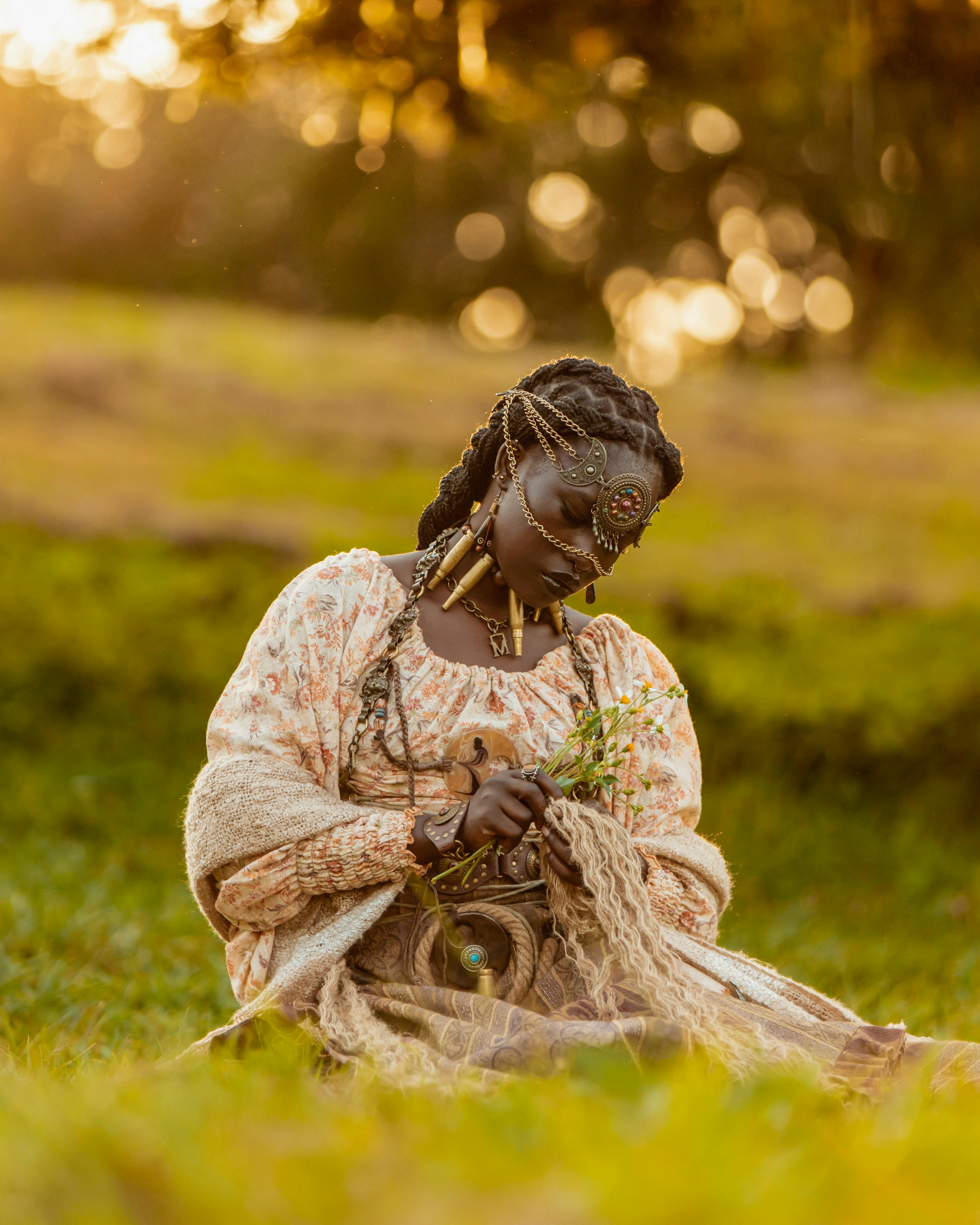 a woman wearing a costume and head jewelry posing on a meadow