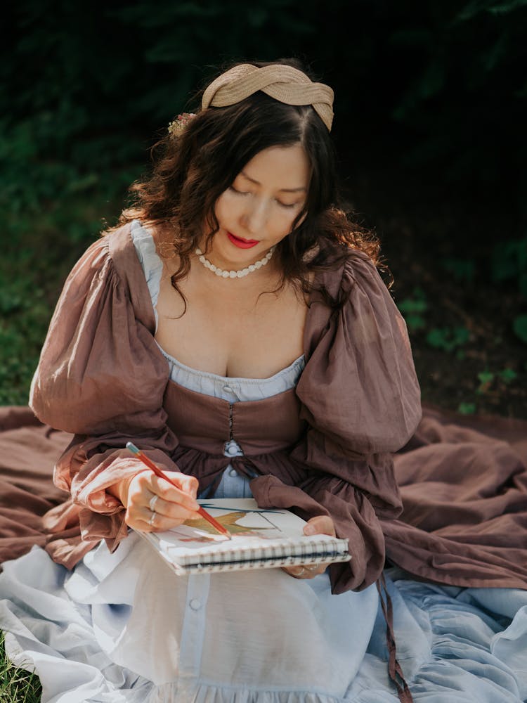 Woman Sitting And Drawing In Notebook