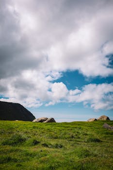 Beautiful grassy landscape with rocks under a cloudy sky in Eggum, Norway.