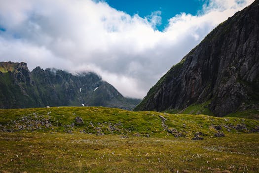 Dramatic landscape of Eggum with lush green hills and towering mountains under a blue sky.