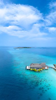 Discover serenity in this aerial view of a stunning overwater bungalow amidst the turquoise waters of Maldives islands.