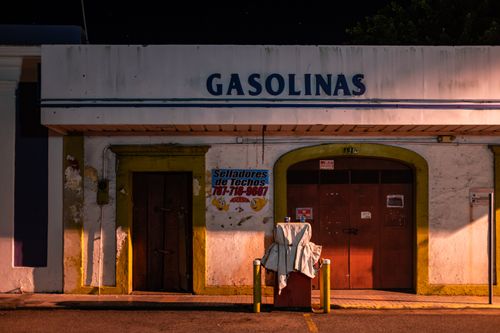 Free Old gas station with worn facade and signage, captured at night in a street scene. Stock Photo