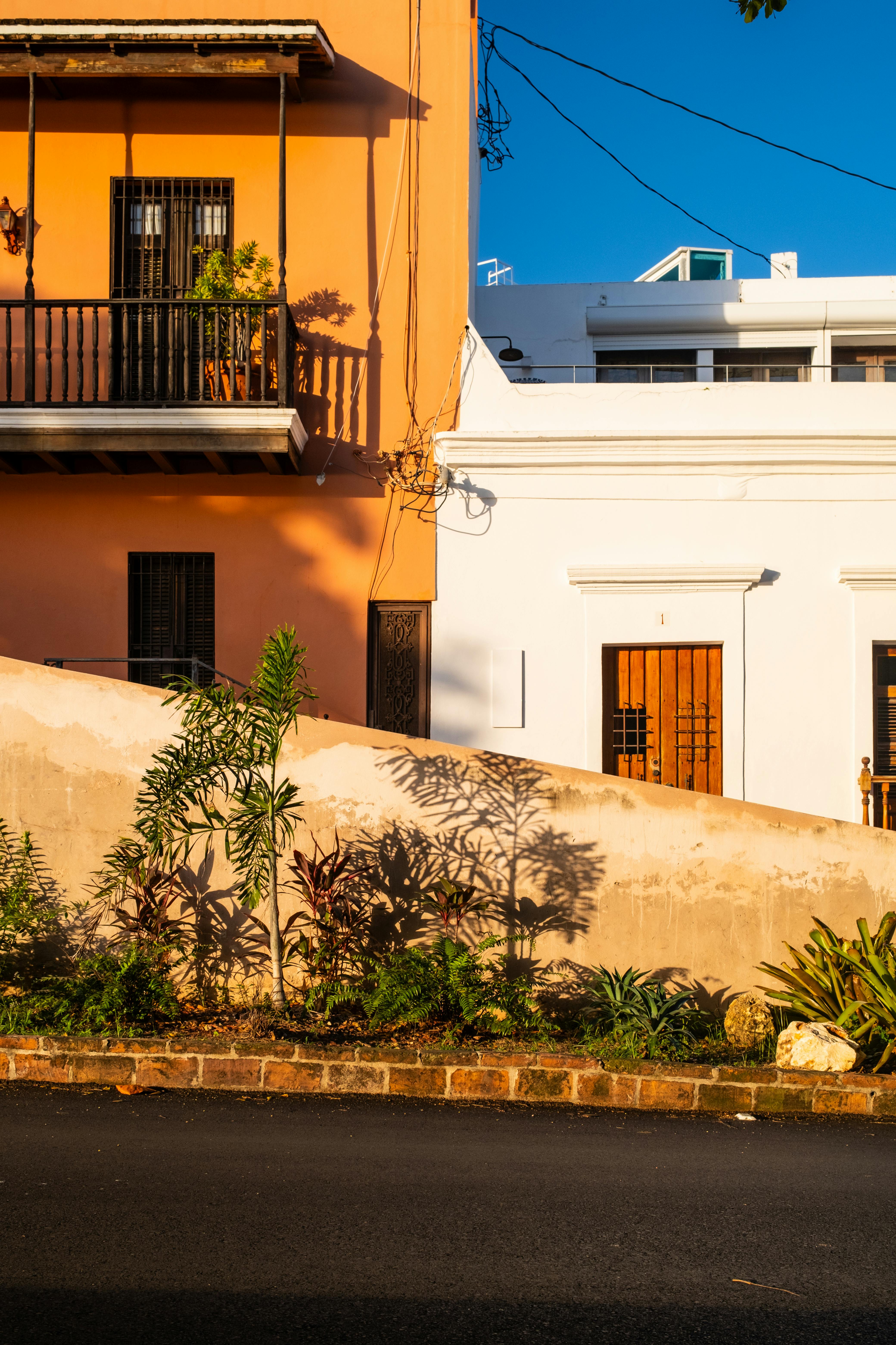 Warm sunlight casts shadows on vibrant urban buildings.