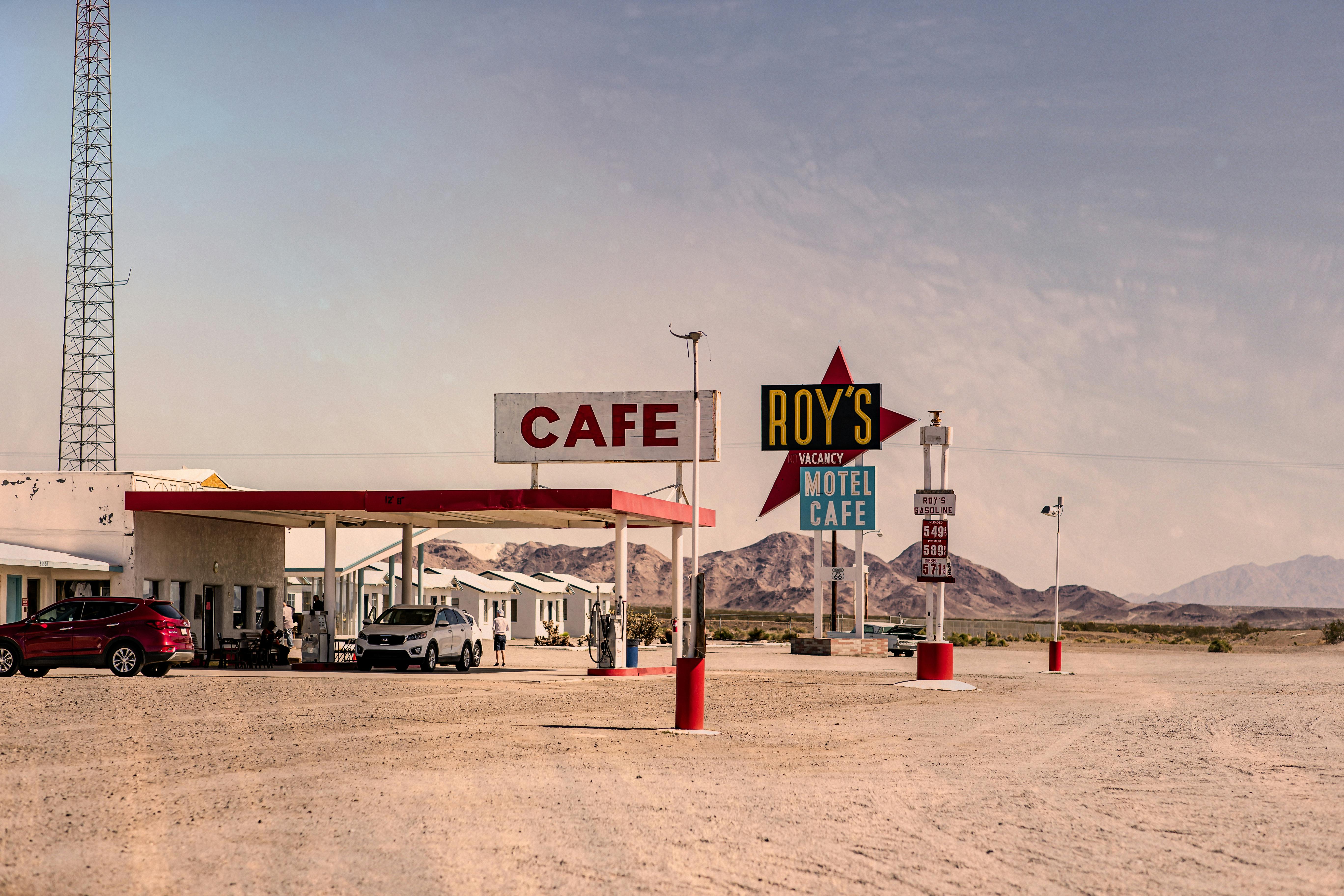 A classic view of Roy's Motel and Cafe in the desert with vintage signs and barren surroundings.