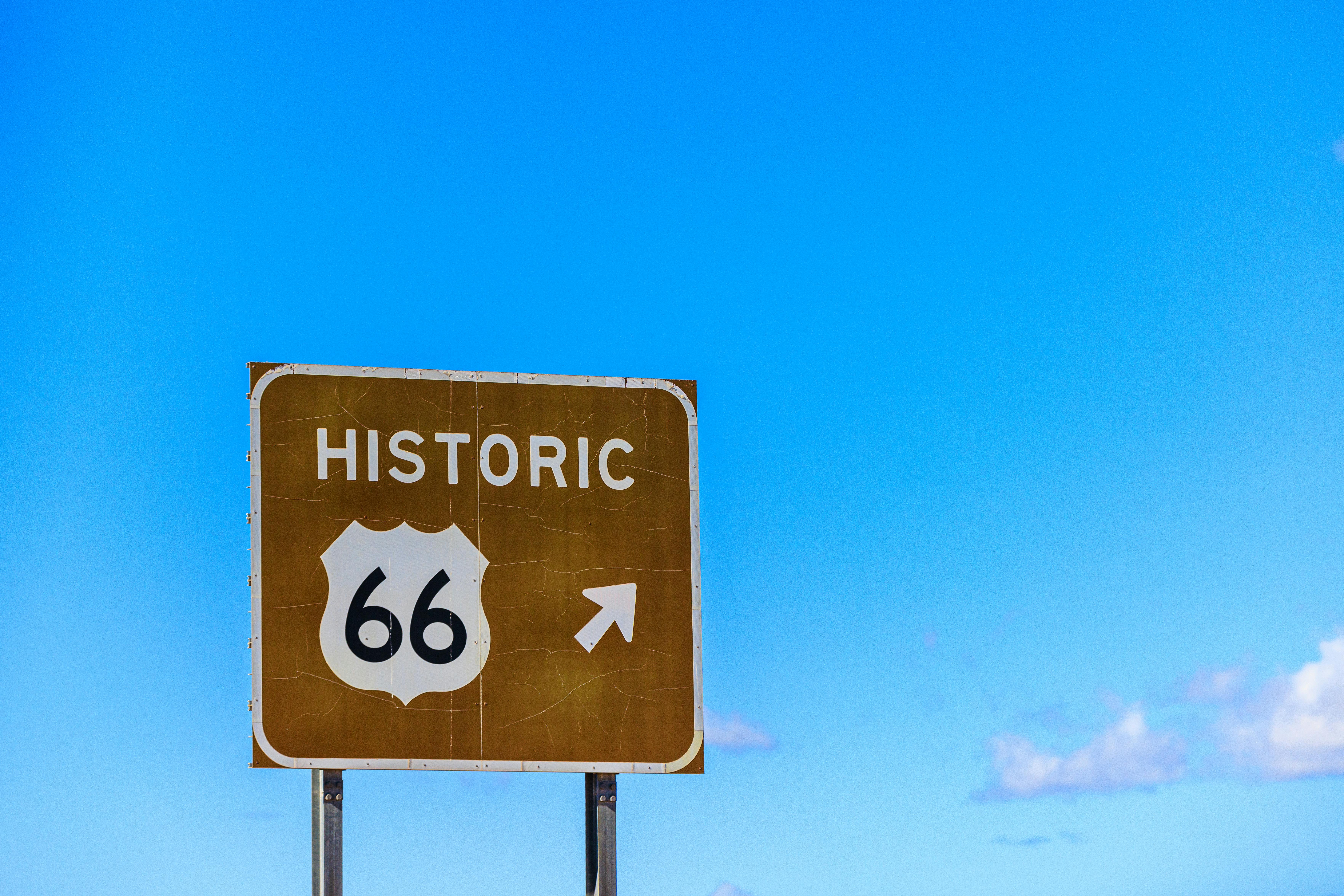 Capture of Historic Route 66 sign with clear blue sky background symbolizing travel and adventure.