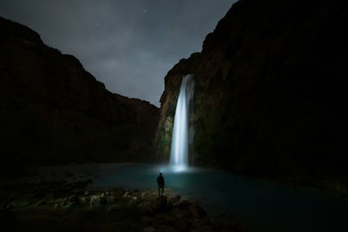 Человек, стоящий у водопада