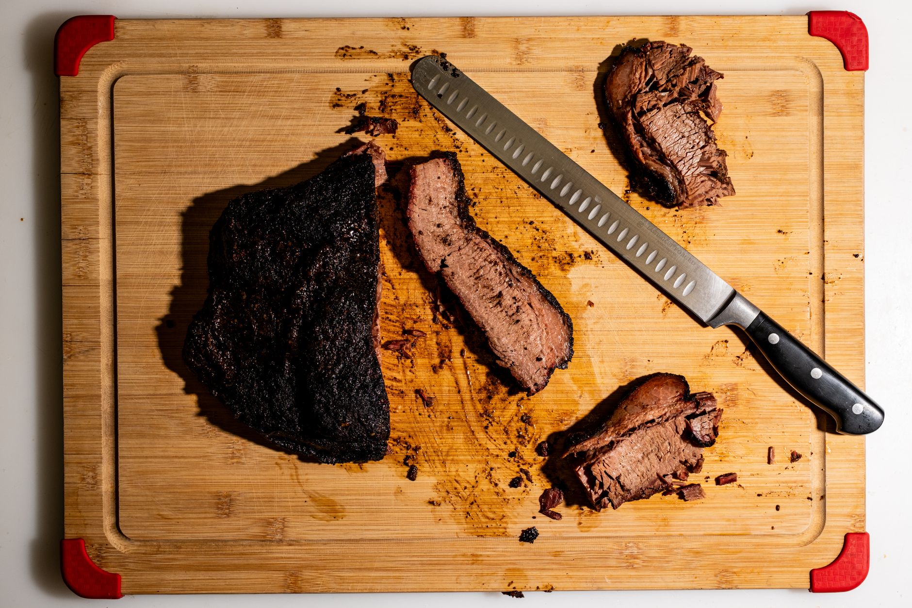 Smoked brisket slices on a cutting board with seasoning